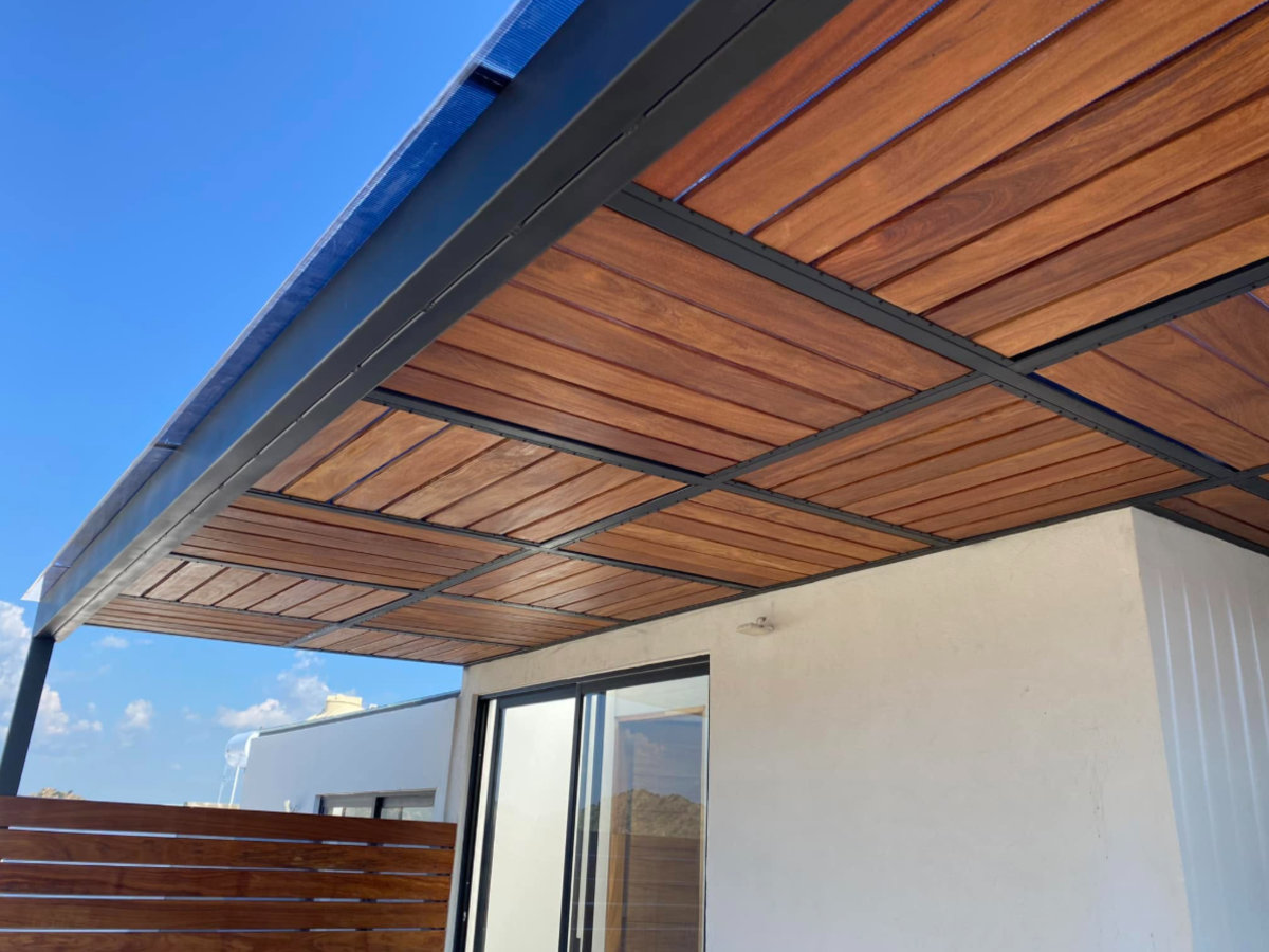 Pérgola metálica con cubierta de madera Pérgola metálica con cubierta de listones de madera en una terraza